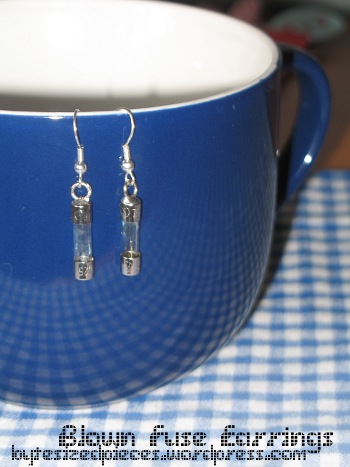 blown fuse earrings hanging over rim of a cup
